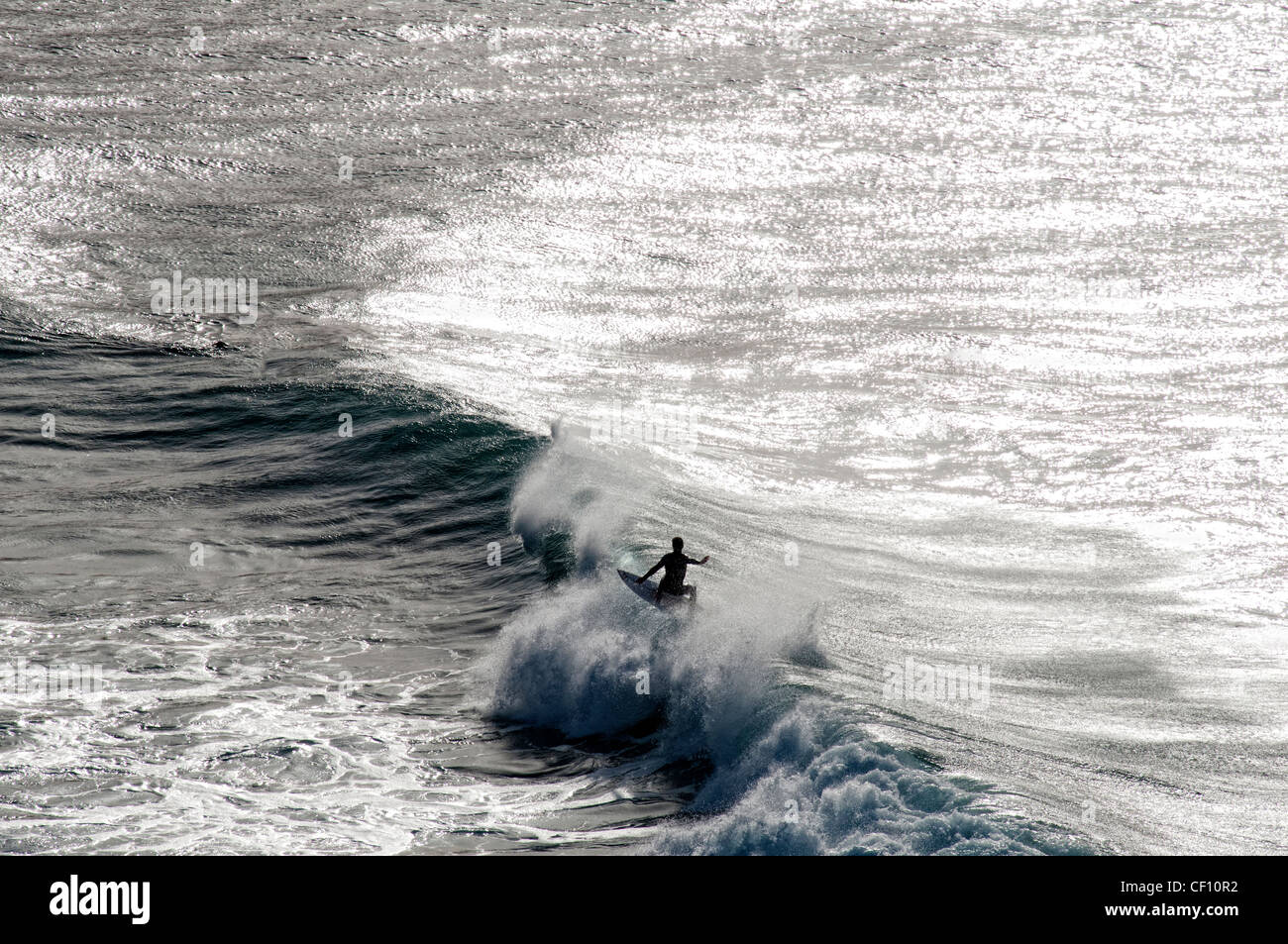 Surfista maschio cavalcare le onde Foto Stock