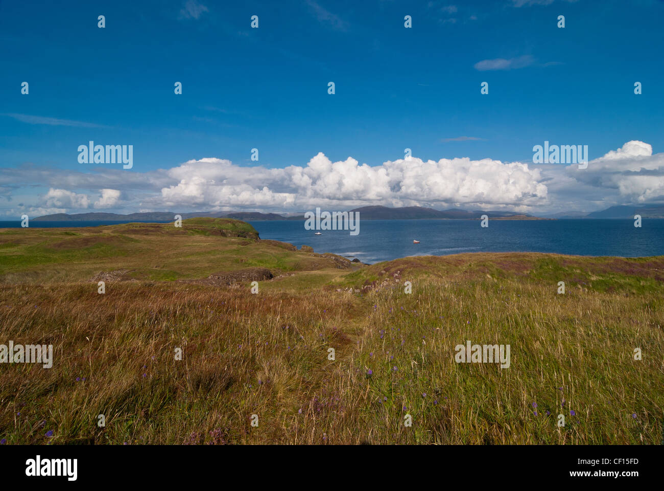 Sull'isola di staffa che guarda al mare con una fascia di cloud nell'orizzonte su Ulva e Mull a distanza Foto Stock