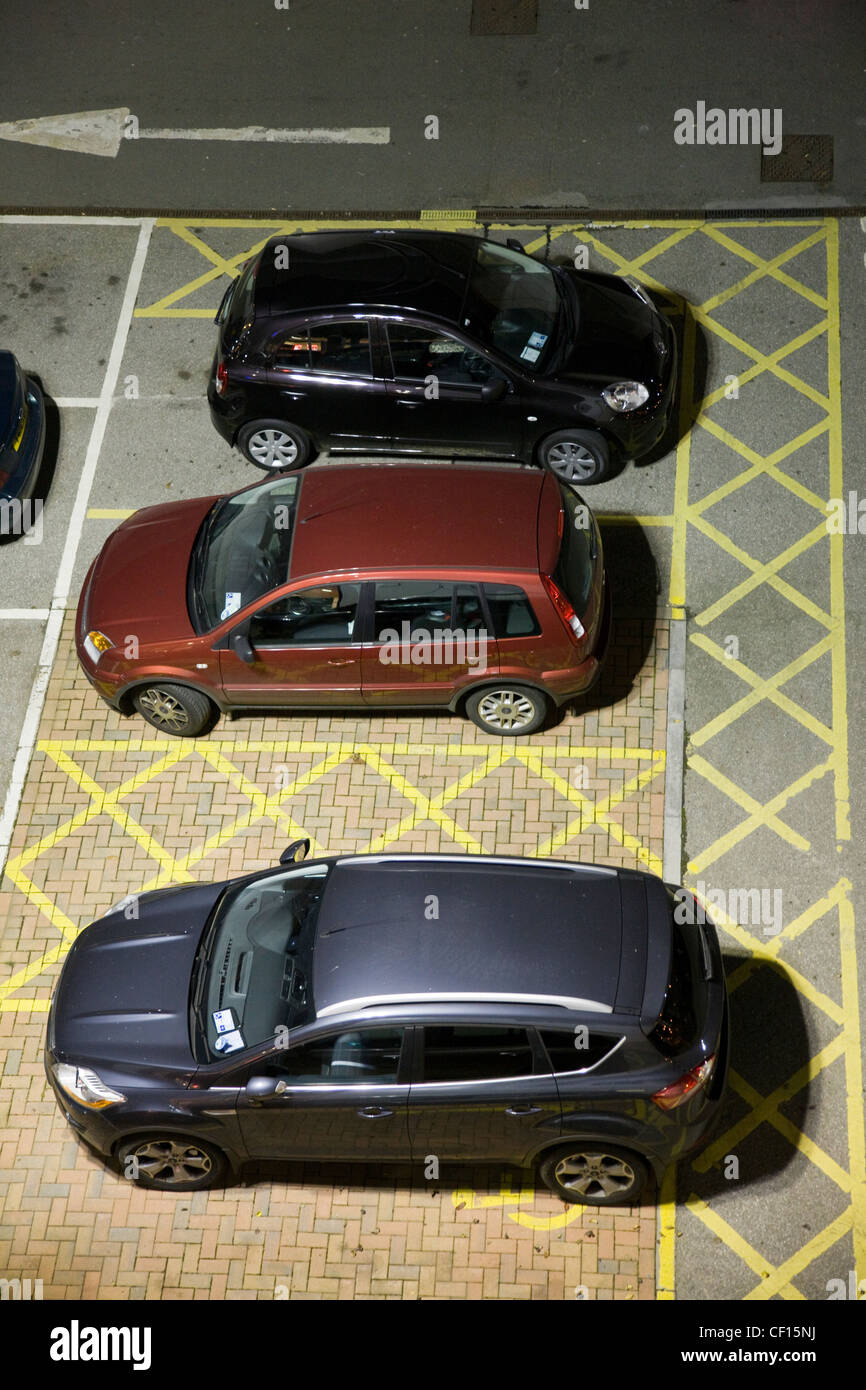 Automobili parcheggiate nel parcheggio disabili posti auto in un parcheggio auto Foto Stock