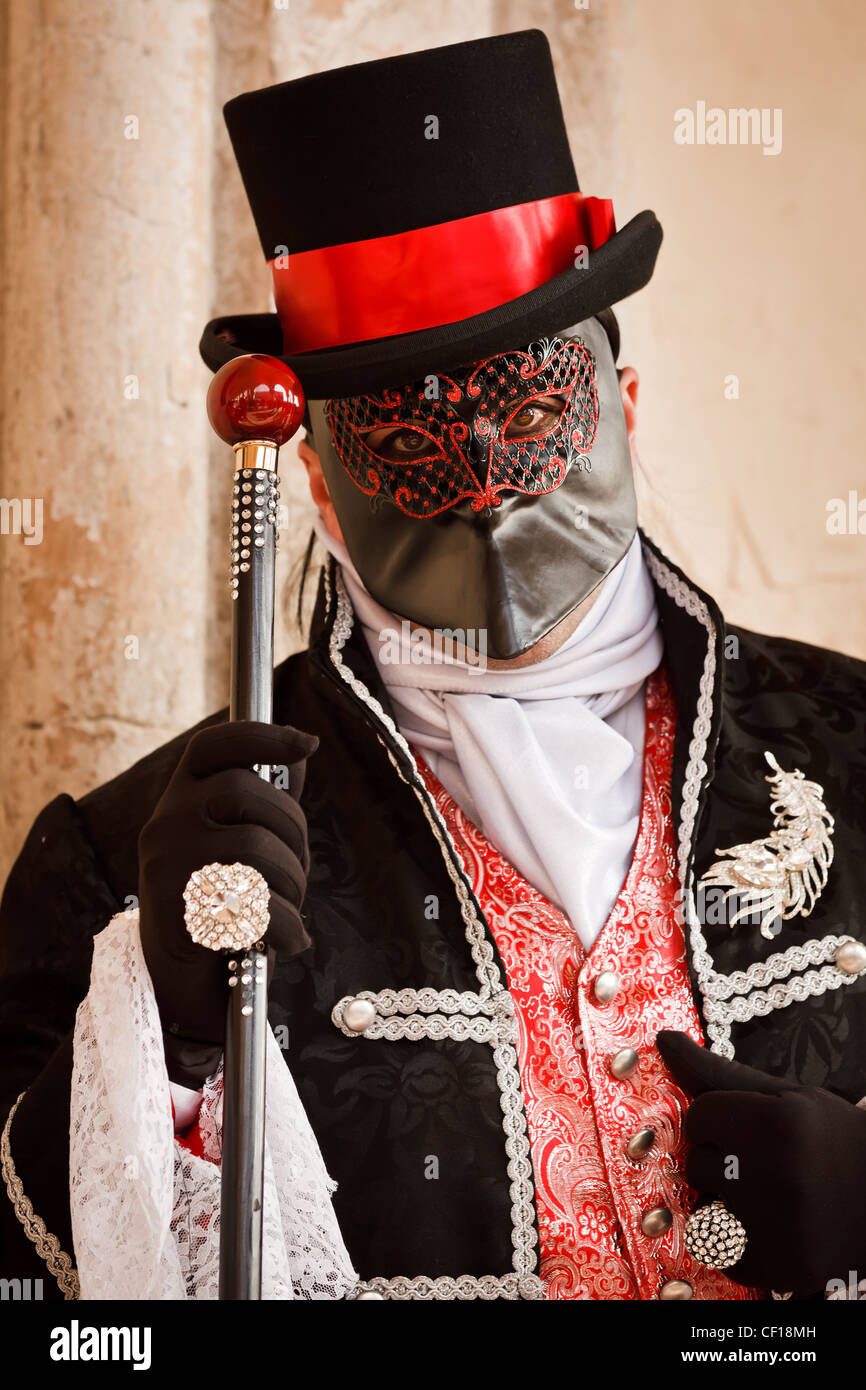 Un uomo con un bastone da passeggio con una riflessione di san Marco  vestite per il Carnevale di Venezia, Veneto, Italia Foto stock - Alamy