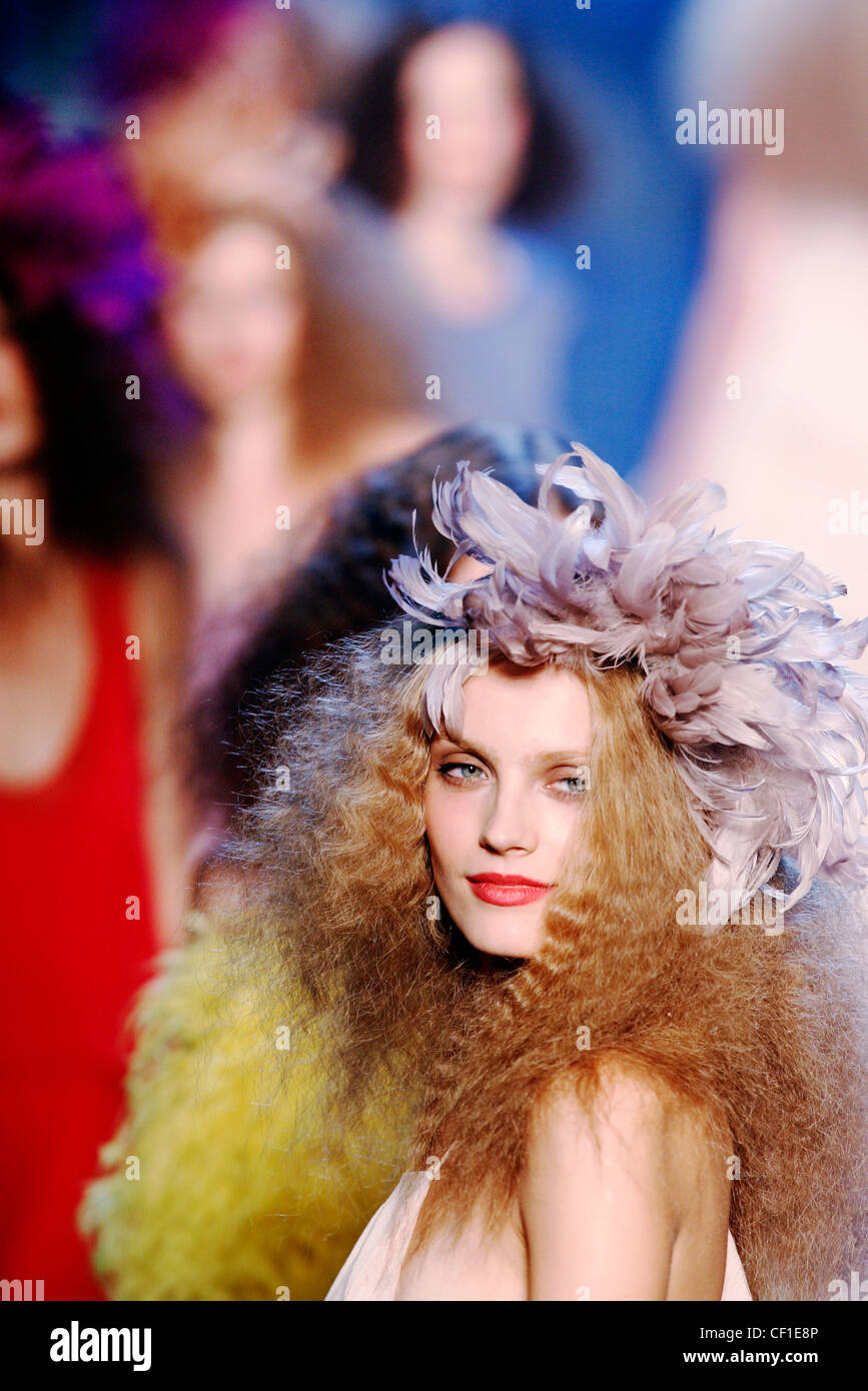 Modello con red frizzy capelli con piume viola decorazione di testa Foto Stock