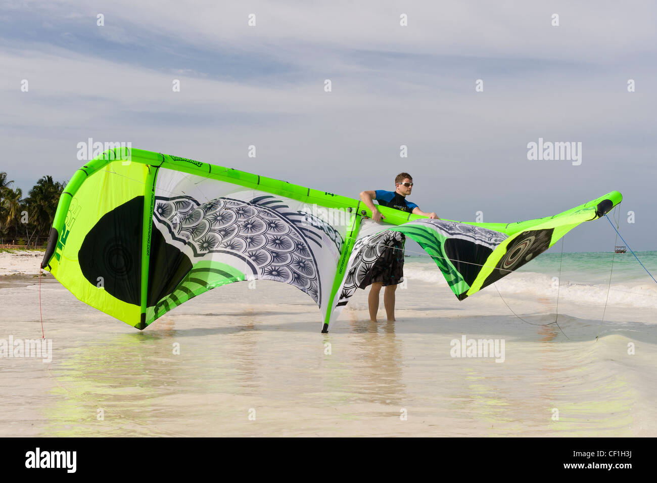 Kite surfer prepara il suo aquilone per lanciare, Paje, Zanzibar, Tanzania Foto Stock