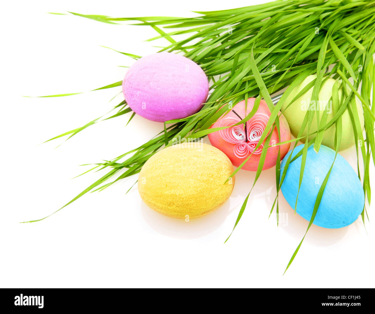 Pasqua uova colorate con erba isolati su sfondo bianco Foto Stock