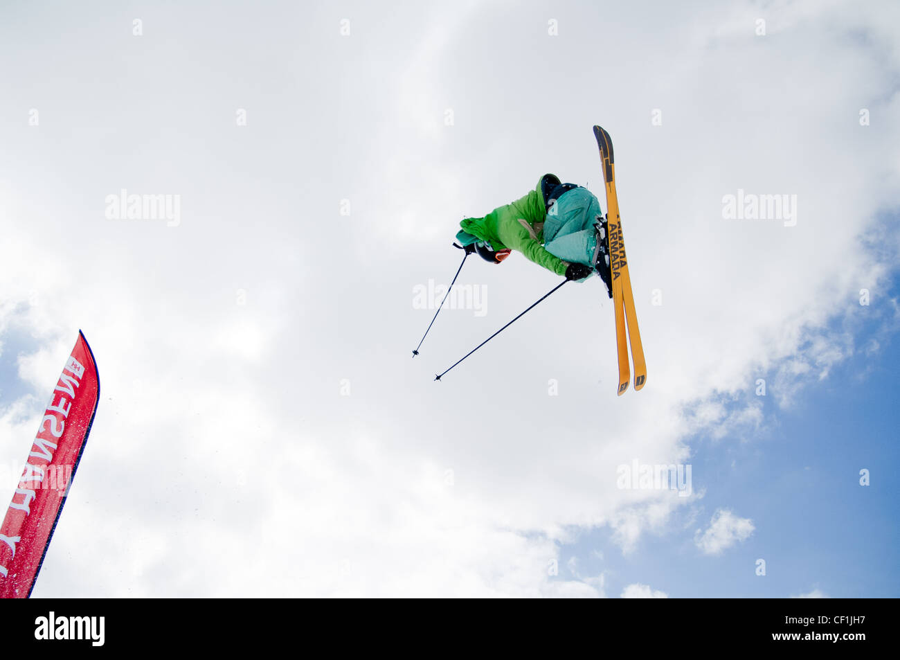 Sciatore getting big air sul vertice di nevis gamma Fort William Highlands scozzesi con il Ben Nevis North Face dietro Foto Stock