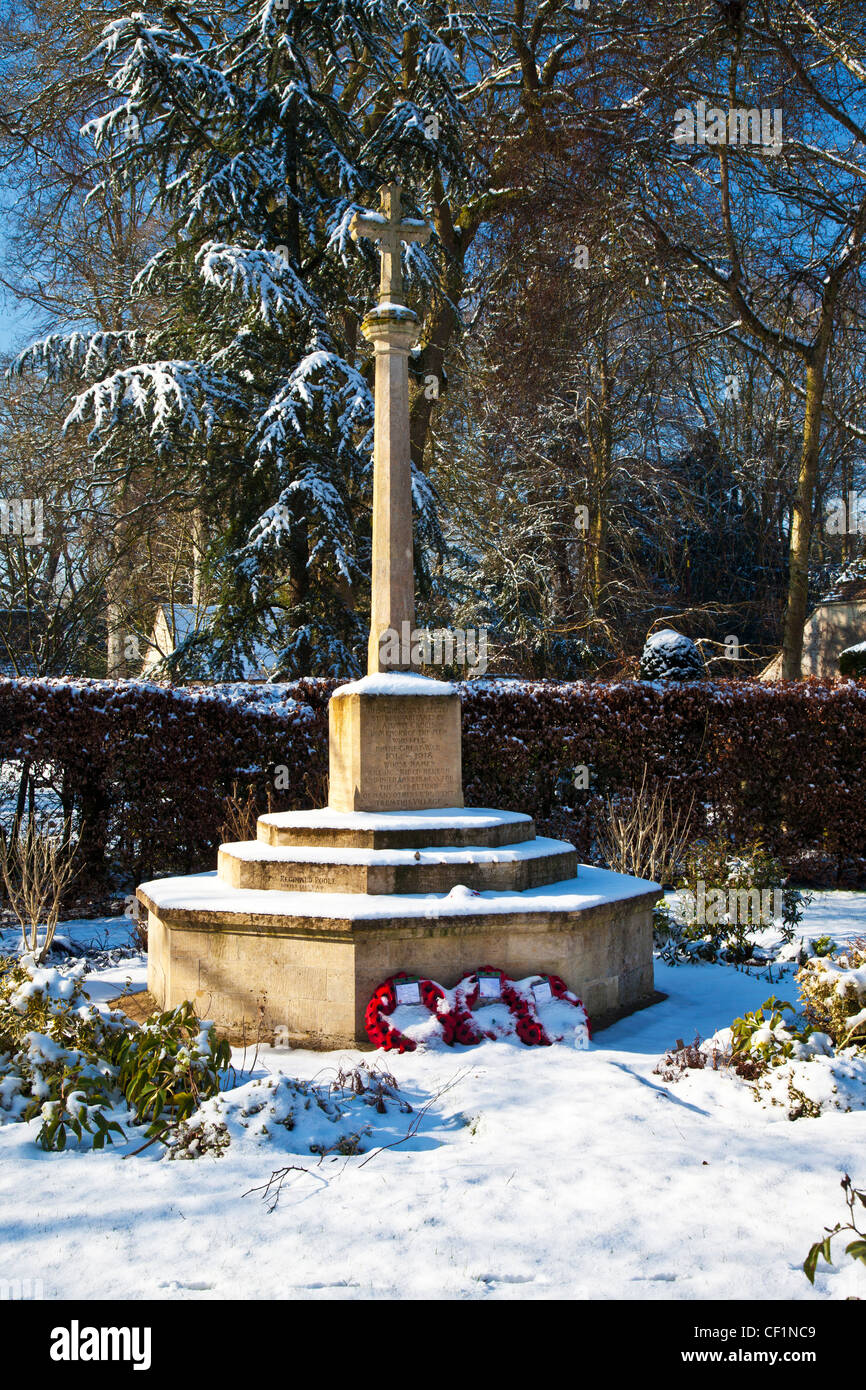Vista invernale della pietra memoriale di guerra croce nel villaggio Costwold di Ampney Crucis, Gloucestershire, England, Regno Unito Foto Stock