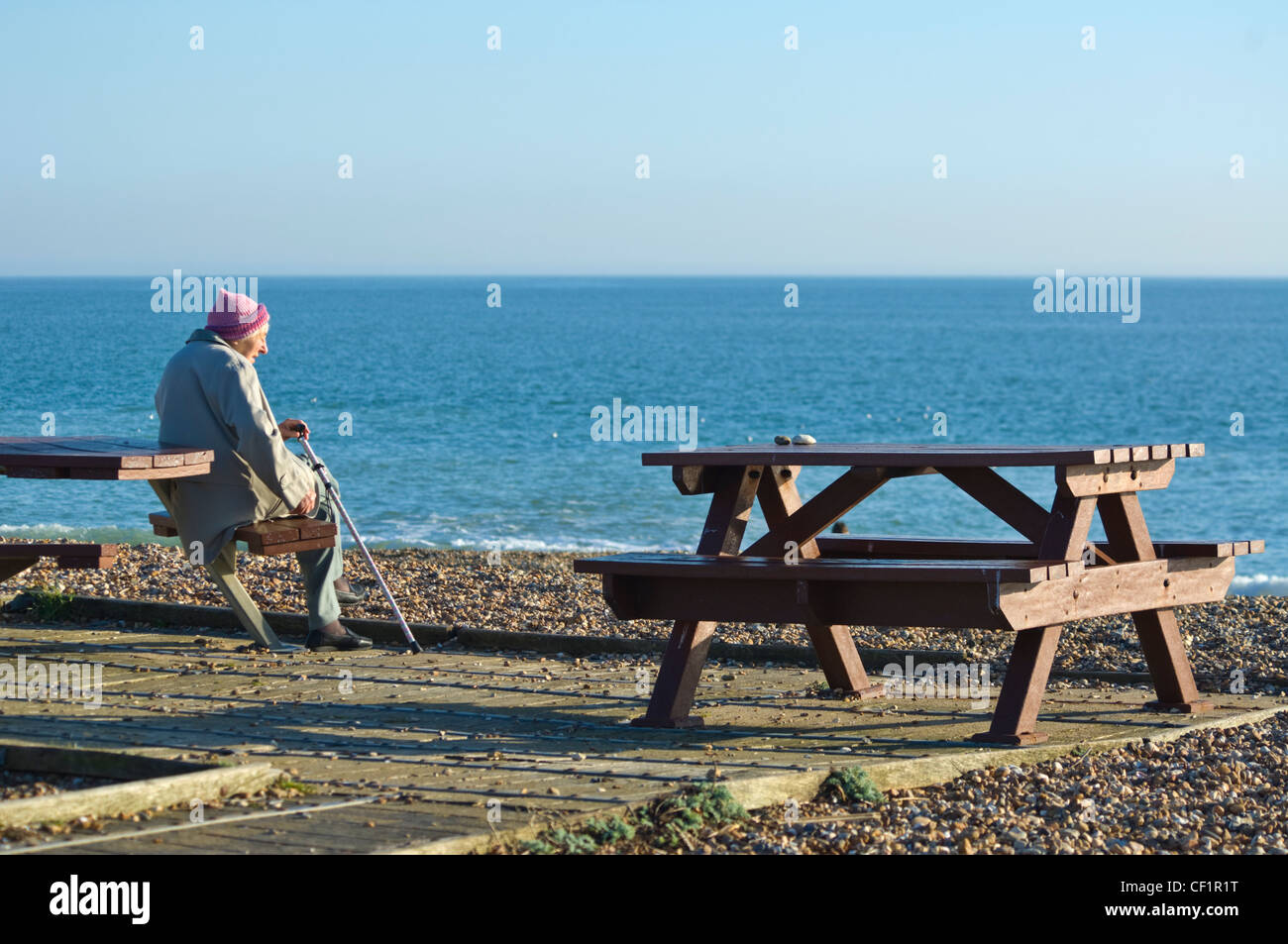 Donna anziana seduto di fronte al mare a Hayling Island Hampshire REGNO UNITO Foto Stock