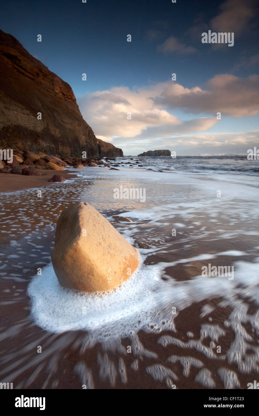 La marea che scorre sulla spiaggia di Saltwick Bay. Foto Stock