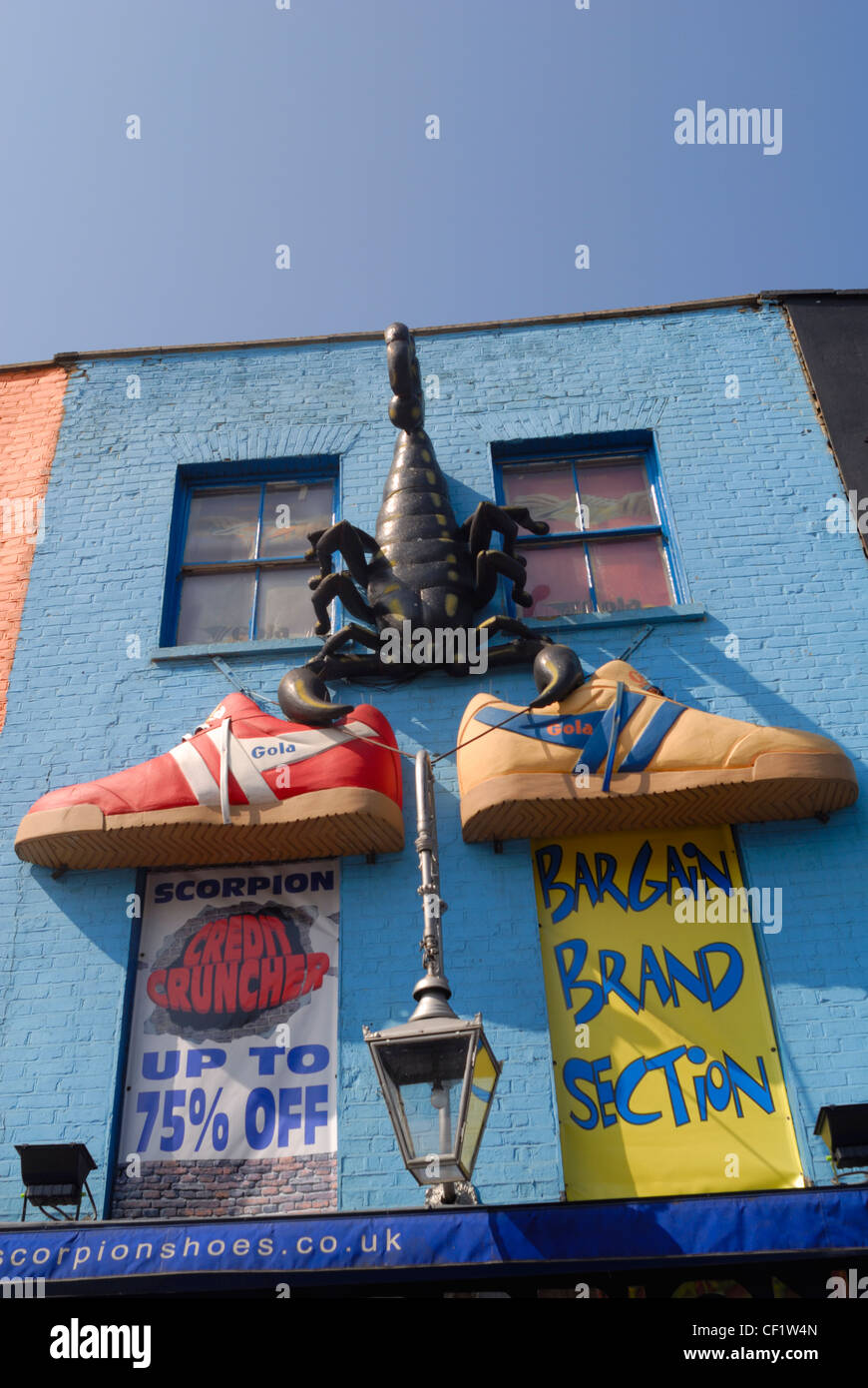 Modelli di due giganti di scarpe da ginnastica e uno scorpione adornano un negozio di fronte a Camden High Street vicino al mercato. Foto Stock