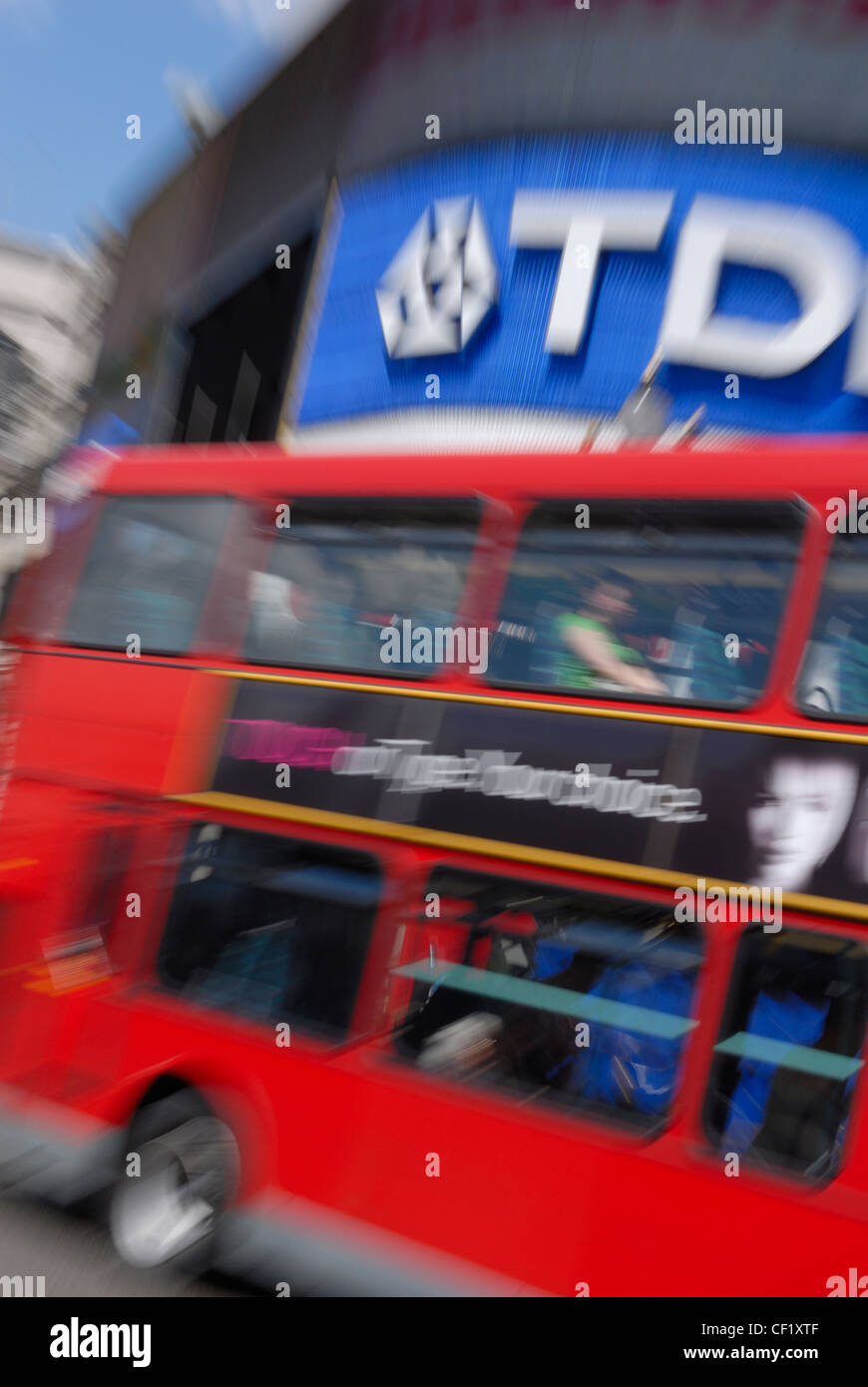 Un rosso London double decker bus che va oltre gli annunci pubblicitari in Piccadilly Circus. Foto Stock