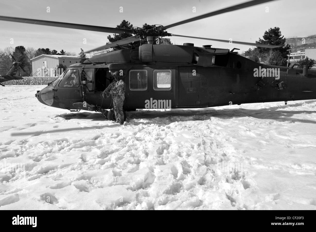 Un membro dell'equipaggio di Black Hawk UH-60 assegnato A UNA Società, 3-82 Aviation Task Force Talon presso il campo aereo dell'Esercito di Bagram, guarda come i membri del servizio partono dalla zona di atterraggio dopo l'atterraggio a Kabul, Afghanistan, 25 febbraio 2012. L'unità conduce missioni di circolazione sul campo di battaglia per la combinazione di Joint Task Force-1, Task Force Poseidon e Task Force Talon. Il Black Hawk UH-60 è in uso dalla fine degli anni '70 e continua ad essere uno degli elicotteri di trasporto tattico di™€ militaryâ più versatili e affidabili. Foto Stock