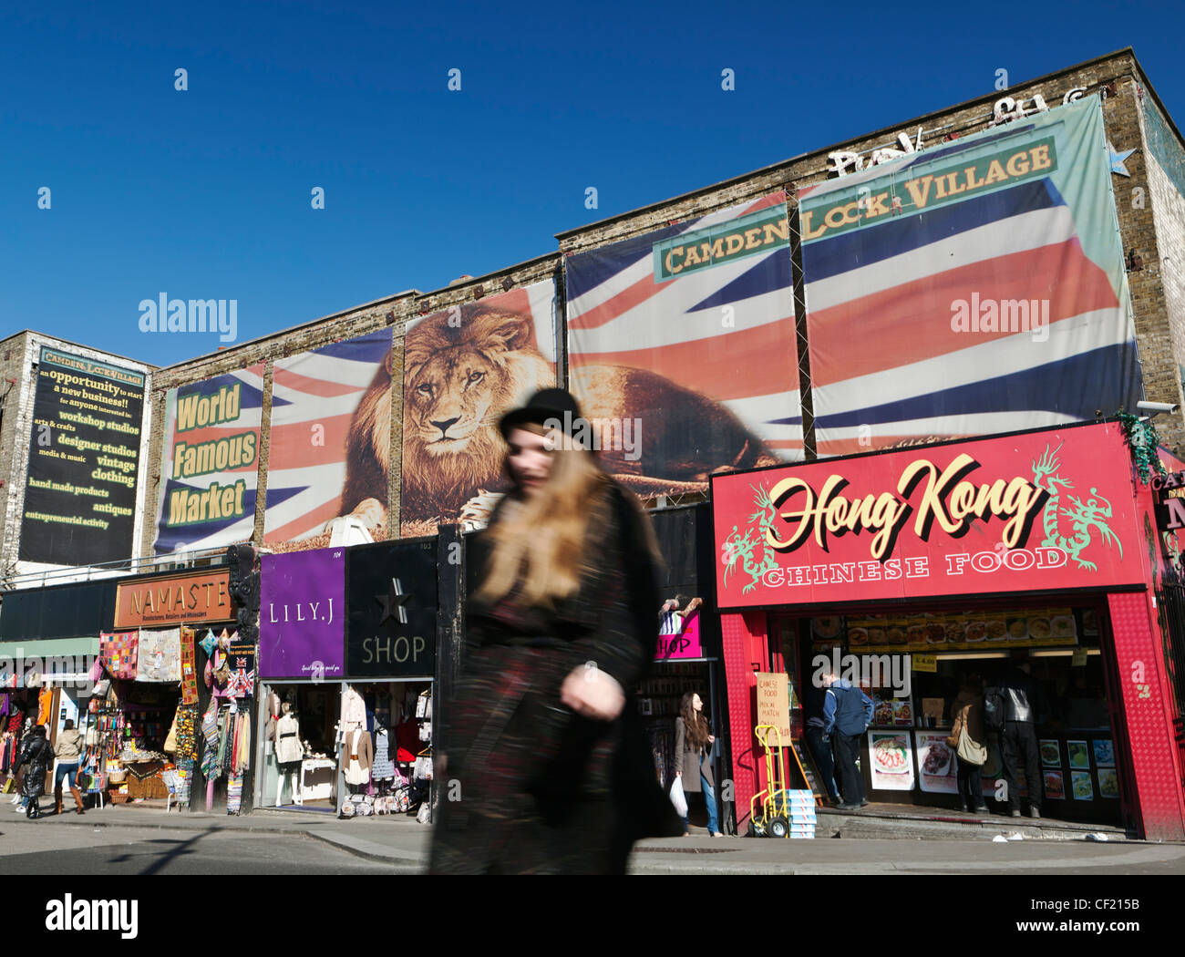 Una donna che indossa un cappello bowler attraversando la strada in Camden Lock Village, casa del famoso mercato. Foto Stock