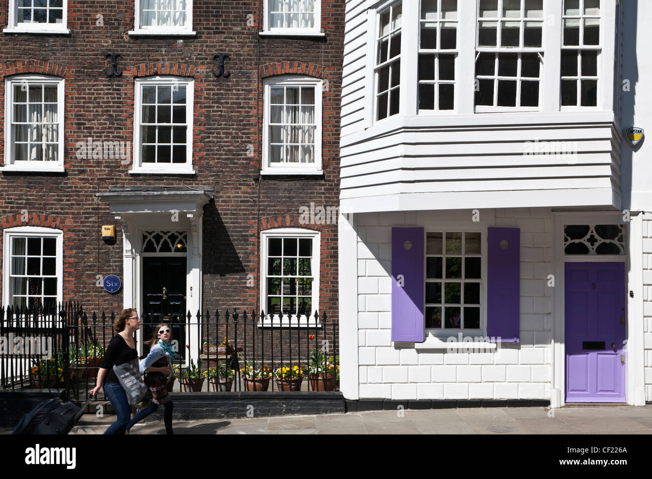 Una madre e figlia oltrepassando le eleganti villette a schiera in chiesa fila, Hampstead, uno dei più completi stree georgiano Foto Stock