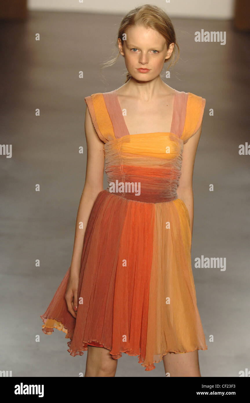 Verrier New York pronto a indossare Primavera Estate bionda modello femminile indossando un arancio listati raccolte dress ruched corpetto e Foto Stock