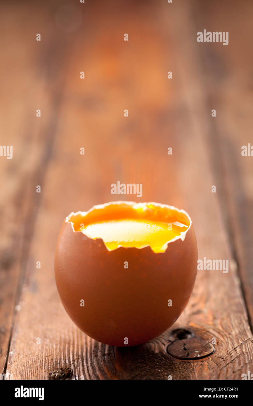 Aperto il guscio delle uova con tuorlo d'uovo su legno Foto Stock