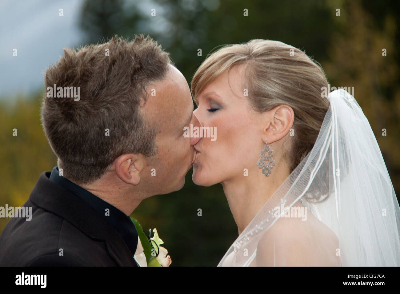 Sposa e lo sposo kiss durante la cerimonia di nozze Foto Stock