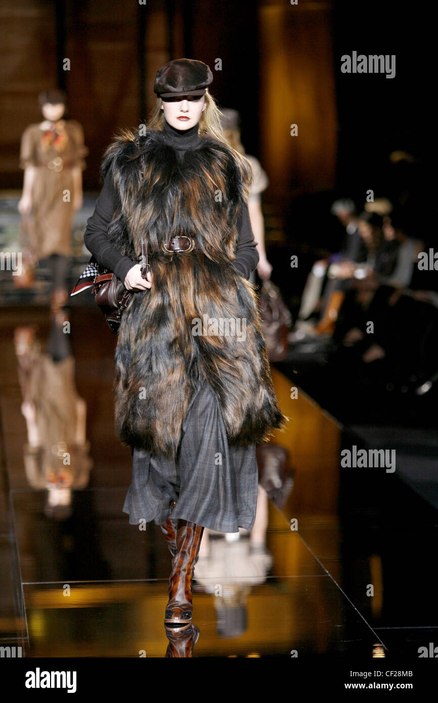 Dolce & Gabbana pronto a indossare in autunno e inverno capelli lunghi sleeveless pelliccia su collo polo, controllato gonna, marrone stivali in pelle Foto Stock