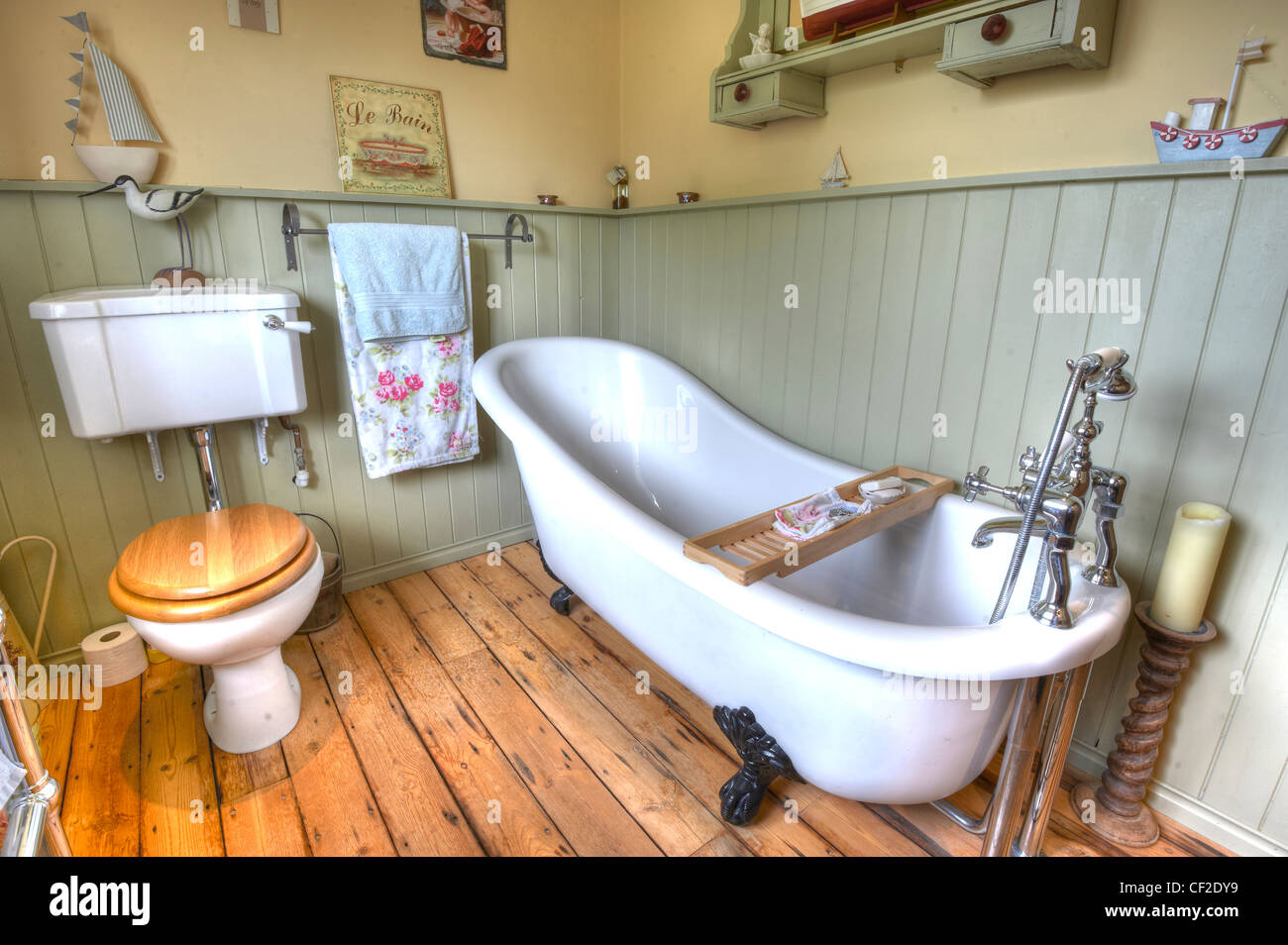 Un accogliente stile shaker bagno, con un roll-top vasca, basso livello di wc, ornamenti di legno su una barca in tema. Foto Stock