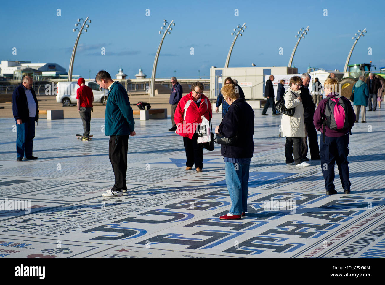 Persone in piedi sul tappeto di commedia, uno dei più grandi pezzi di arte pubblica mai commissionato nel Regno Unito, a Blackpool Promenad Foto Stock