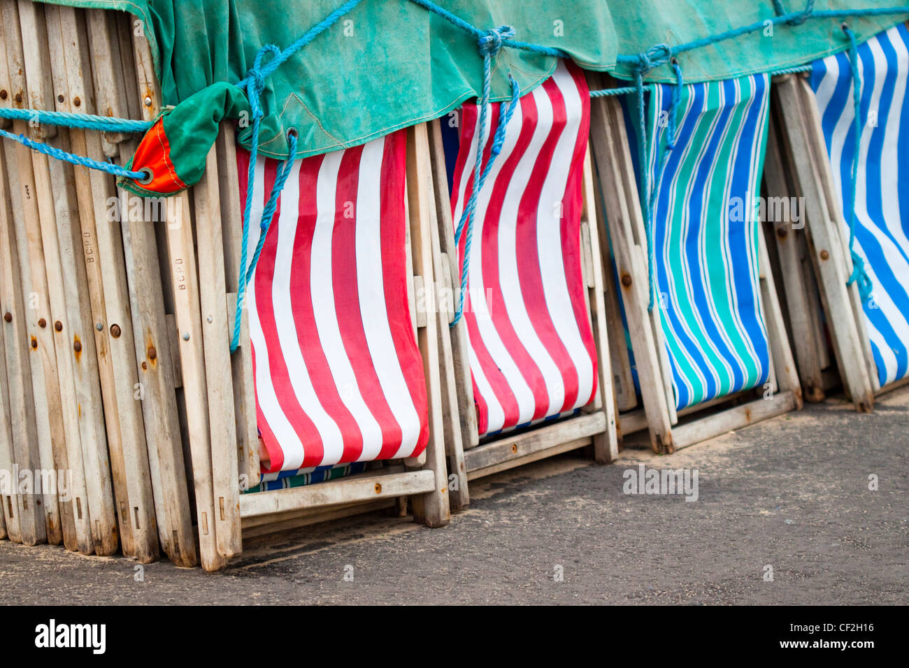 Le sdraio per la spiaggia impilati sul Blackpool Golden Mile. Foto Stock