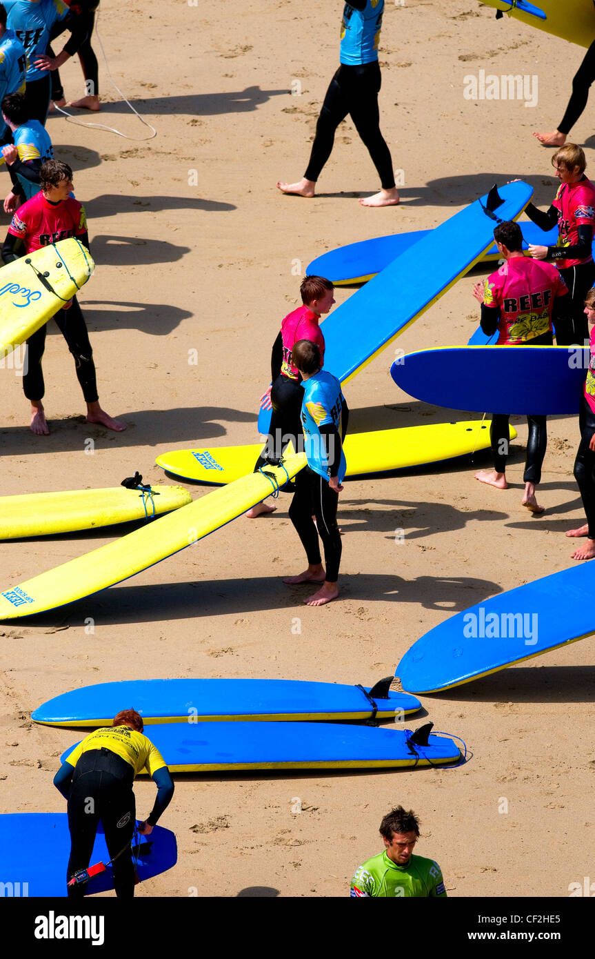 Persone in una scuola di surf su una spiaggia di Newquay. Foto Stock