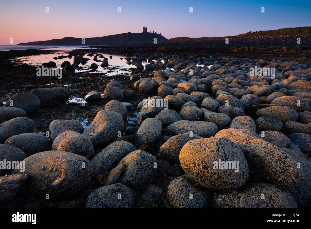 Weathered rocks dominano la bassa marea litorale di Embleton Bay. Foto Stock