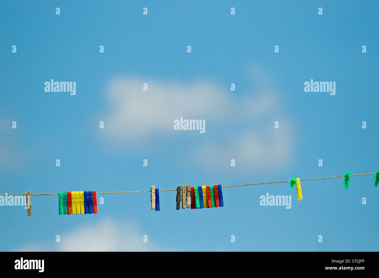 Abbigliamento colorato pioli su una linea di lavaggio contro un cielo blu. Foto Stock