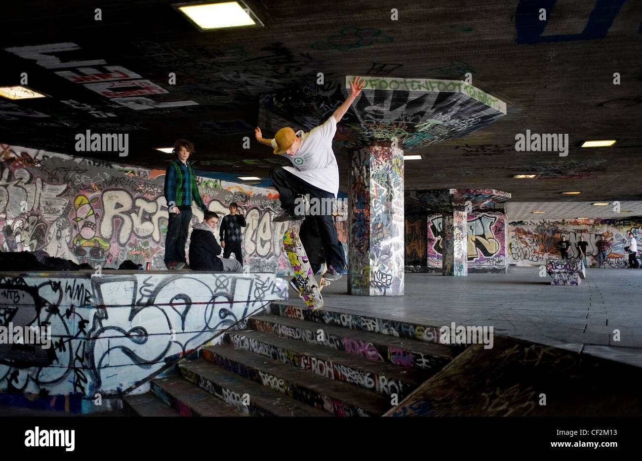 Un guidatore di skateboard eseguendo uno stunt al undercroft sulla banca del sud. Foto Stock