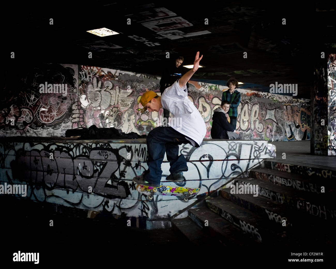 Un guidatore di skateboard eseguendo uno stunt al undercroft sulla banca del sud. Foto Stock