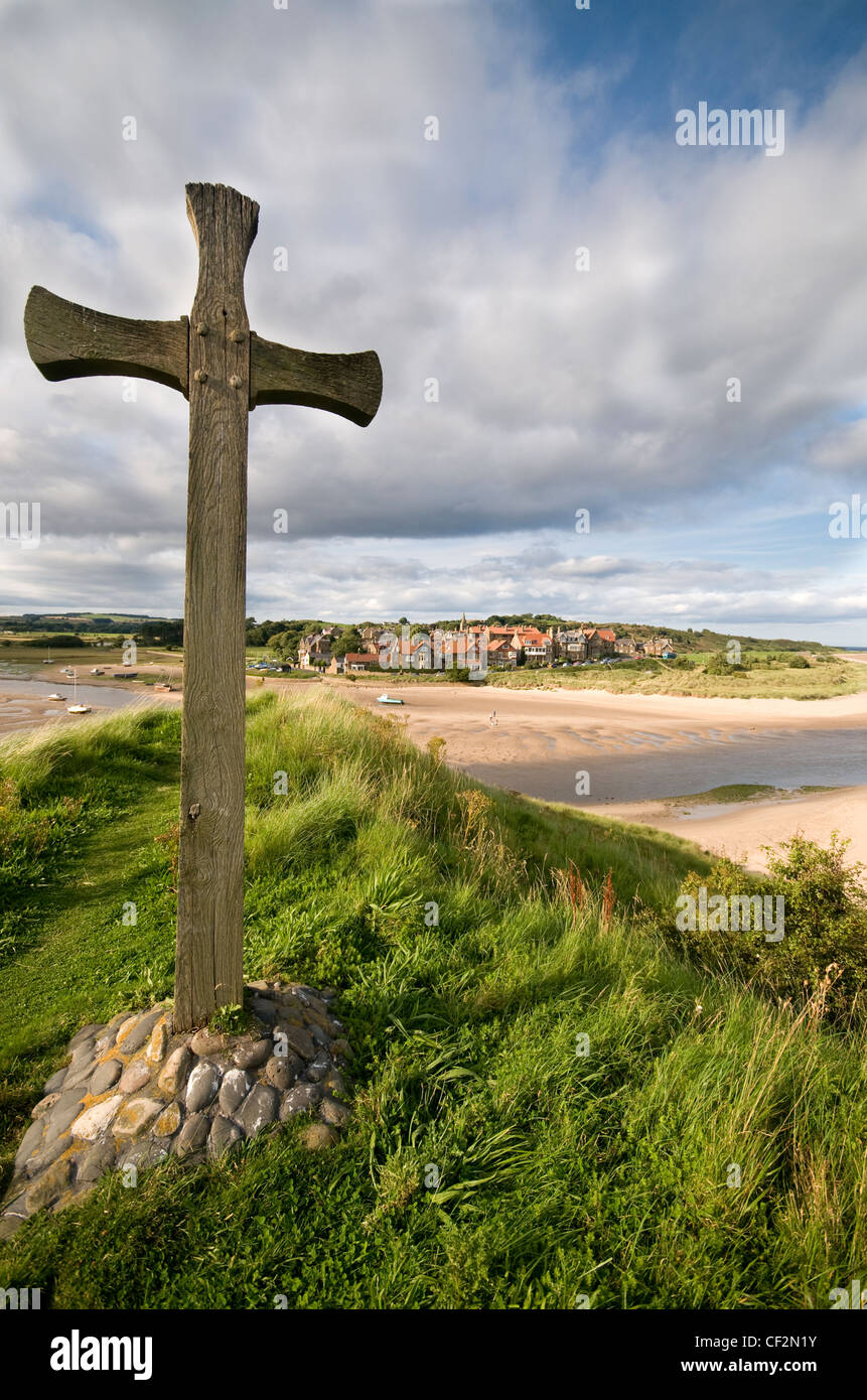 Una croce segna il sito dell'originale chiesa sassone di Alnmouth Affacciato sulla foce del fiume aln. Foto Stock