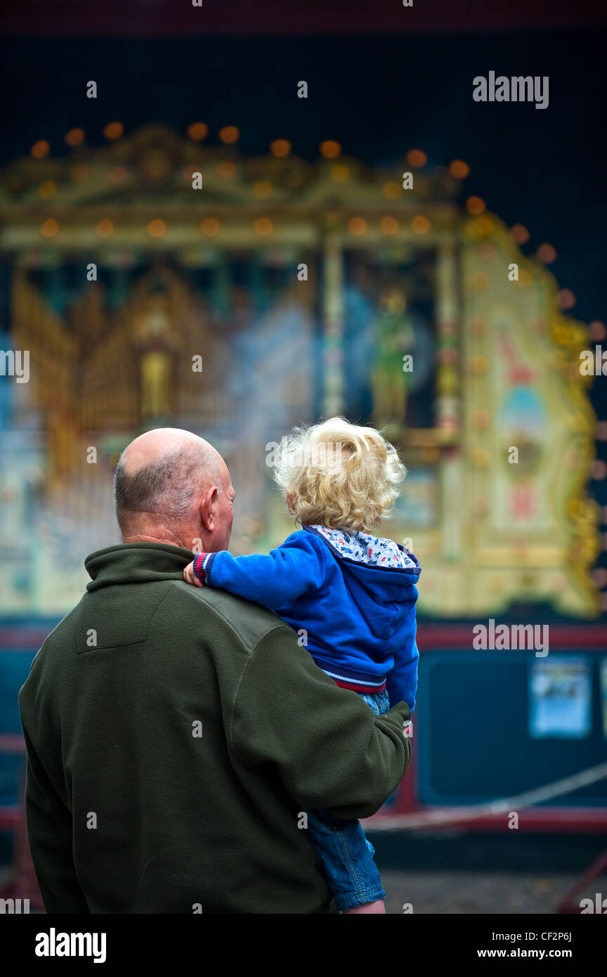 Un nonno e il nipote guardando un organo di vapore al Audley End Gala vapore 2011. Foto Stock