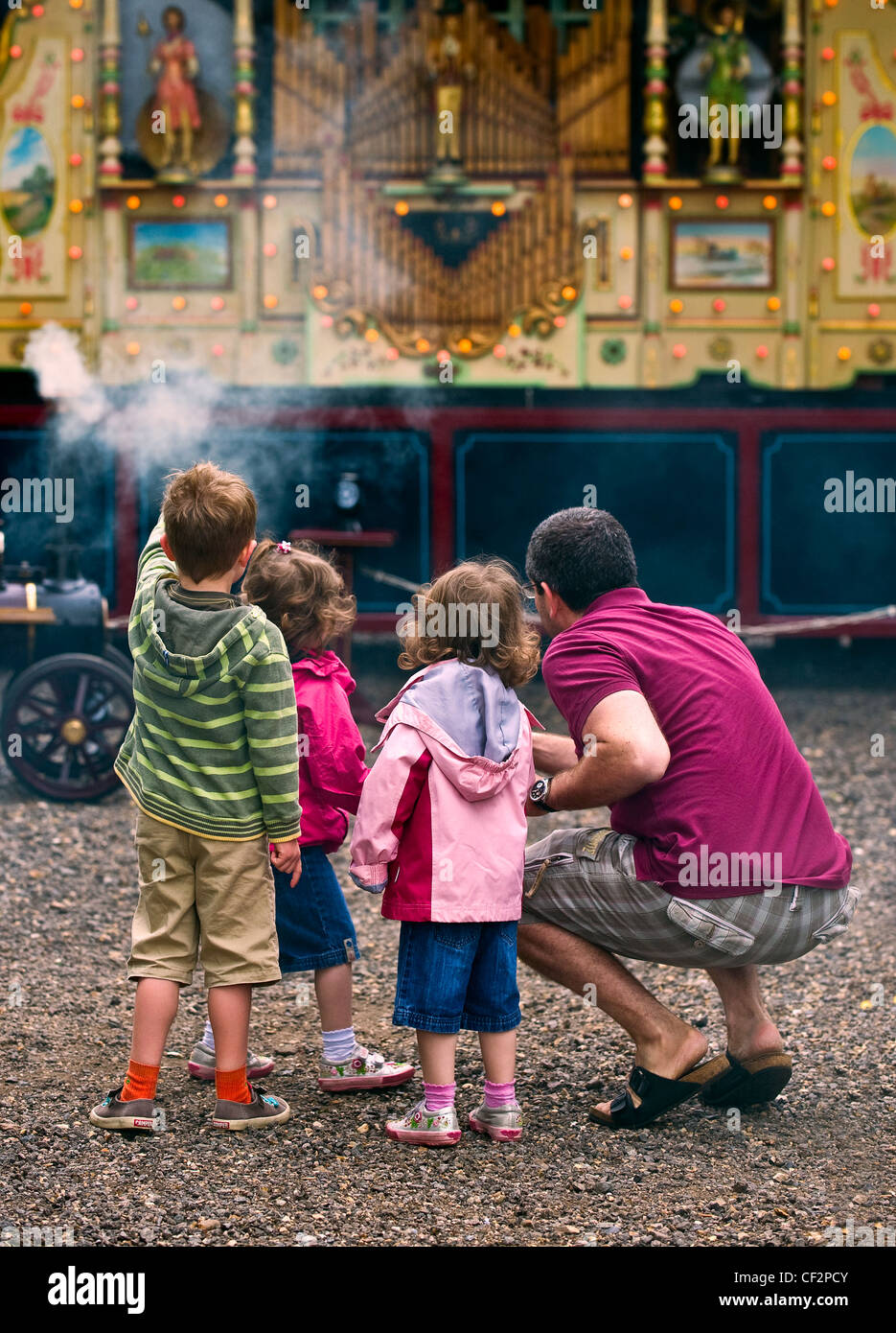 Padre e figli guardando un organo di vapore al Audley End Gala vapore 2011. Foto Stock