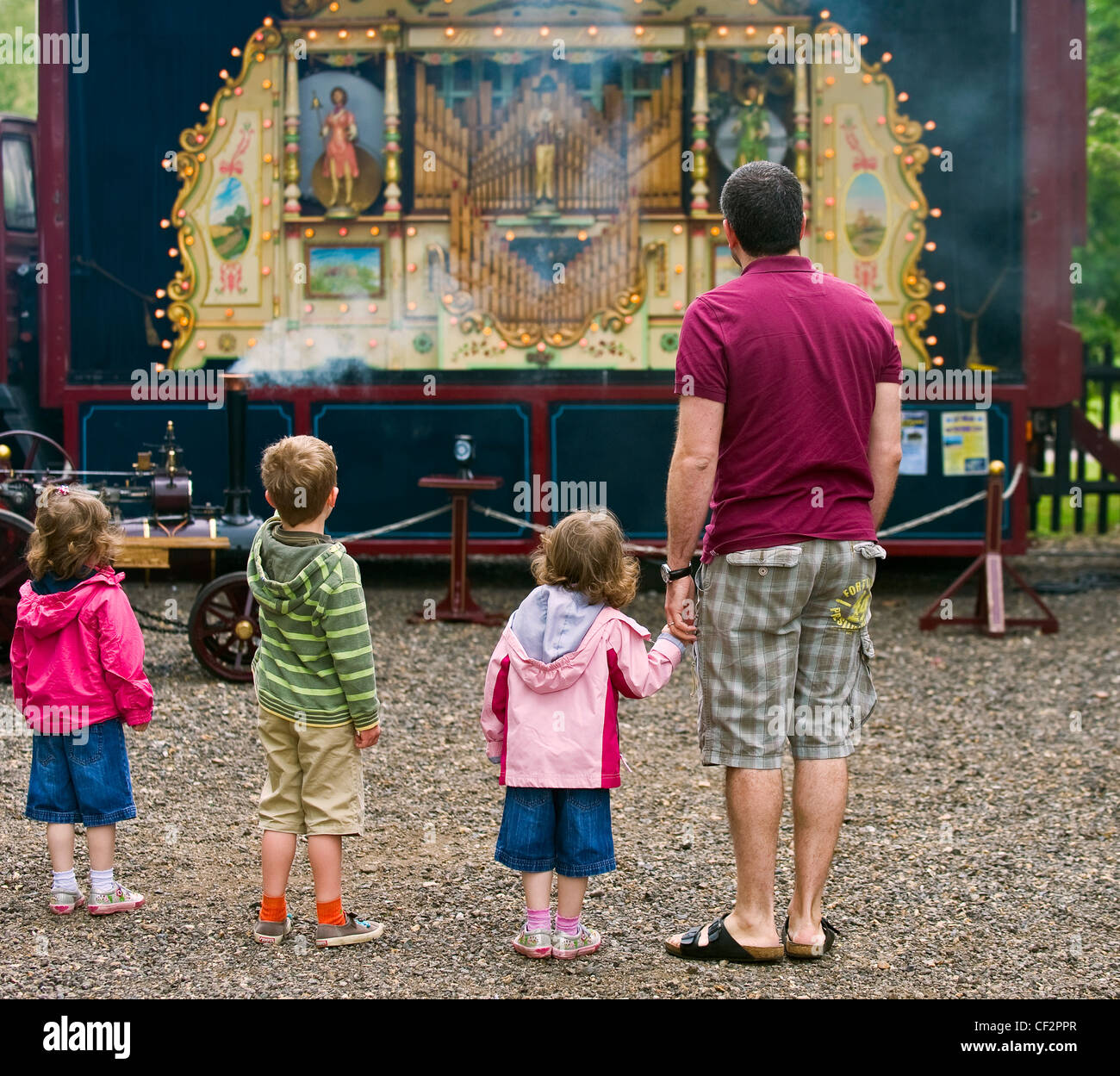 Padre e figli guardando un organo di vapore all'Audley End Gala vapore 2011. Foto Stock