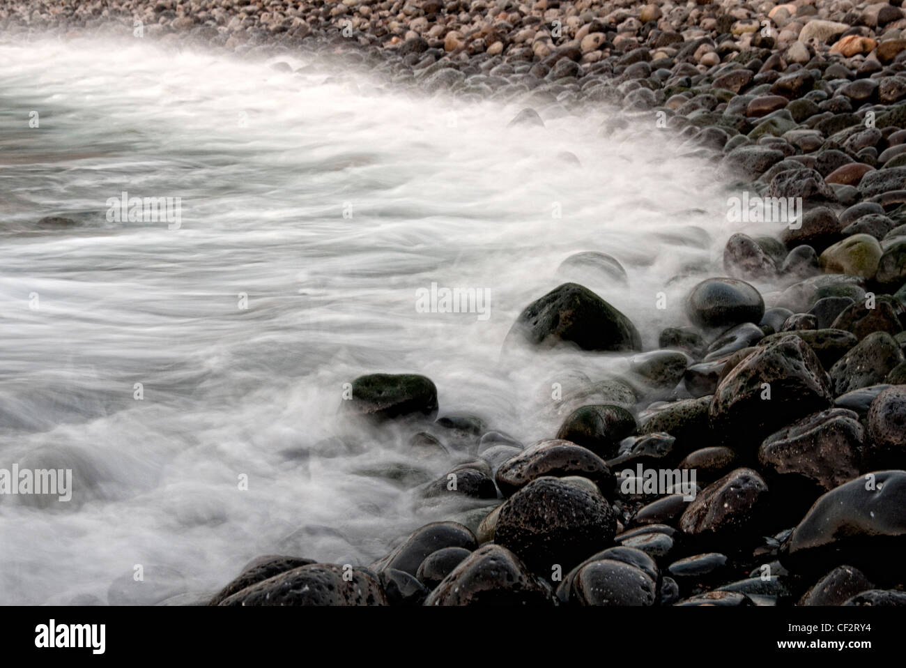 Spiaggia ghiaiosa misty acqua Foto Stock
