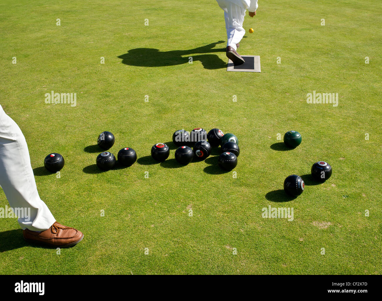 Un bowler impostazione di un marchio con una presa all'inizio di un gioco della corona verdi bocce a Newlyn Bowling Club. Foto Stock