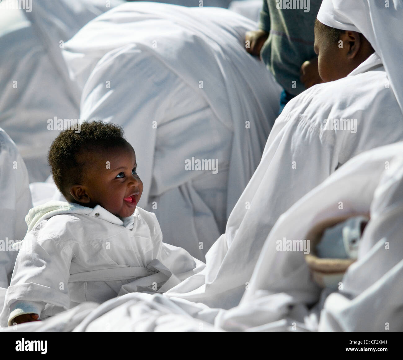 Un bambino e la madre nella congregazione di una chiesa apostolica. Foto Stock