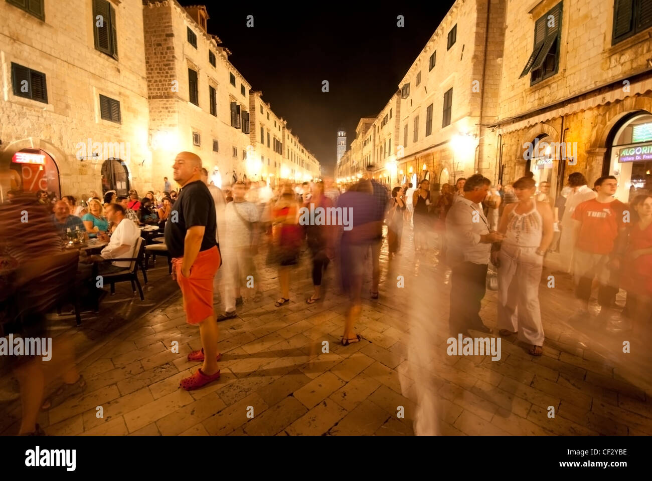 Una vista giù per la strada principale a Dubrovnik di notte con la gente vivace attraverso la scena Foto Stock