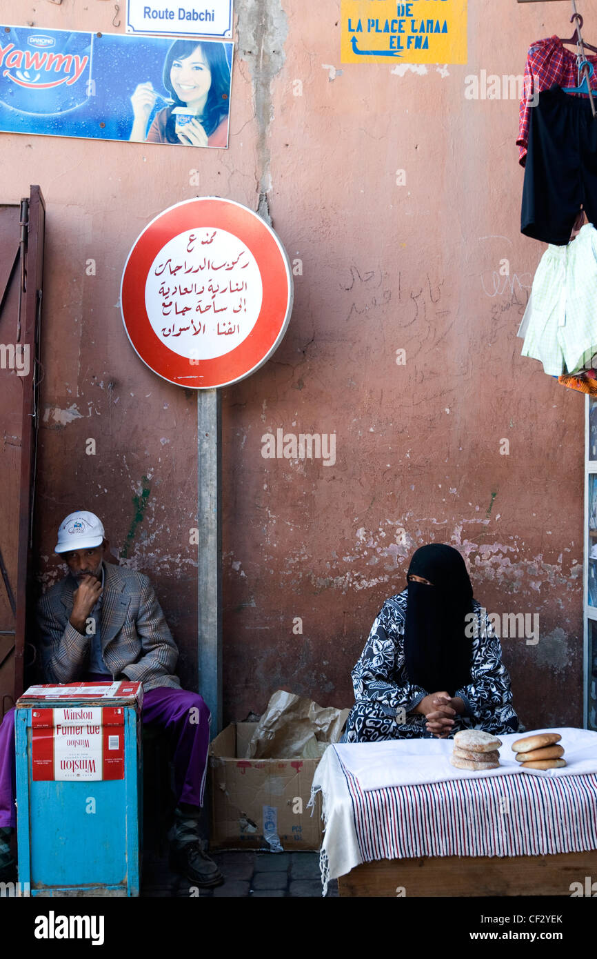 Due venditori locali attendere per i clienti presso la famosa Djemaa el Fna mercato in Marrakech, Marocco Foto Stock