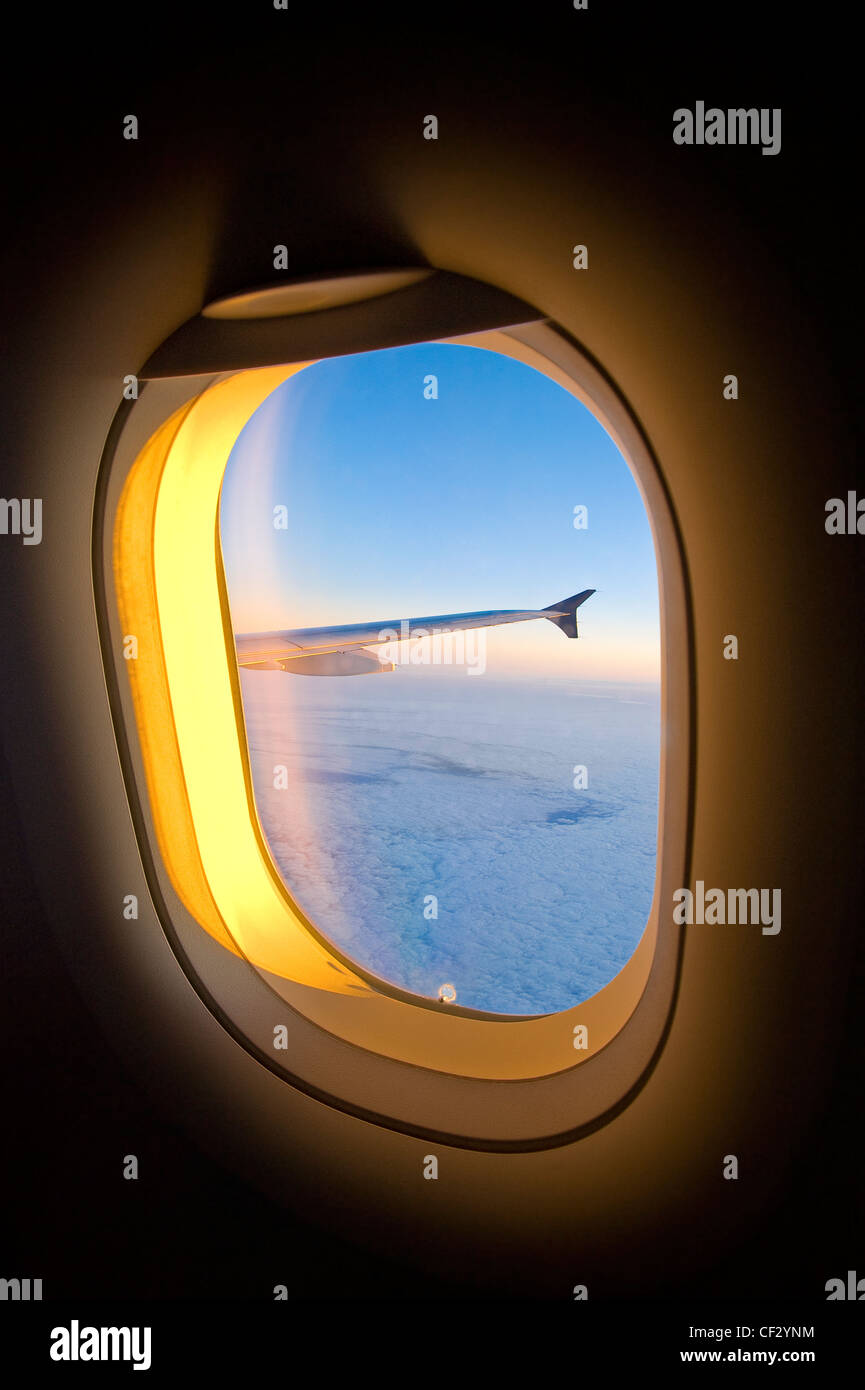 Finestra di aereo con ala Piano & Sunset nuvole Foto Stock