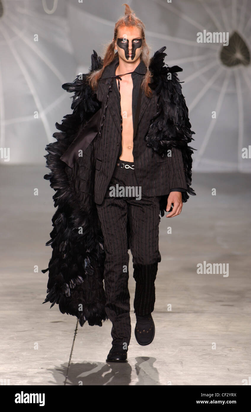 Alexander McQueen Milano Menswear S S maschio nero viso trucco viola da  indossare tuta a strisce, accessoriata di lunga piuma nera boa Foto stock -  Alamy