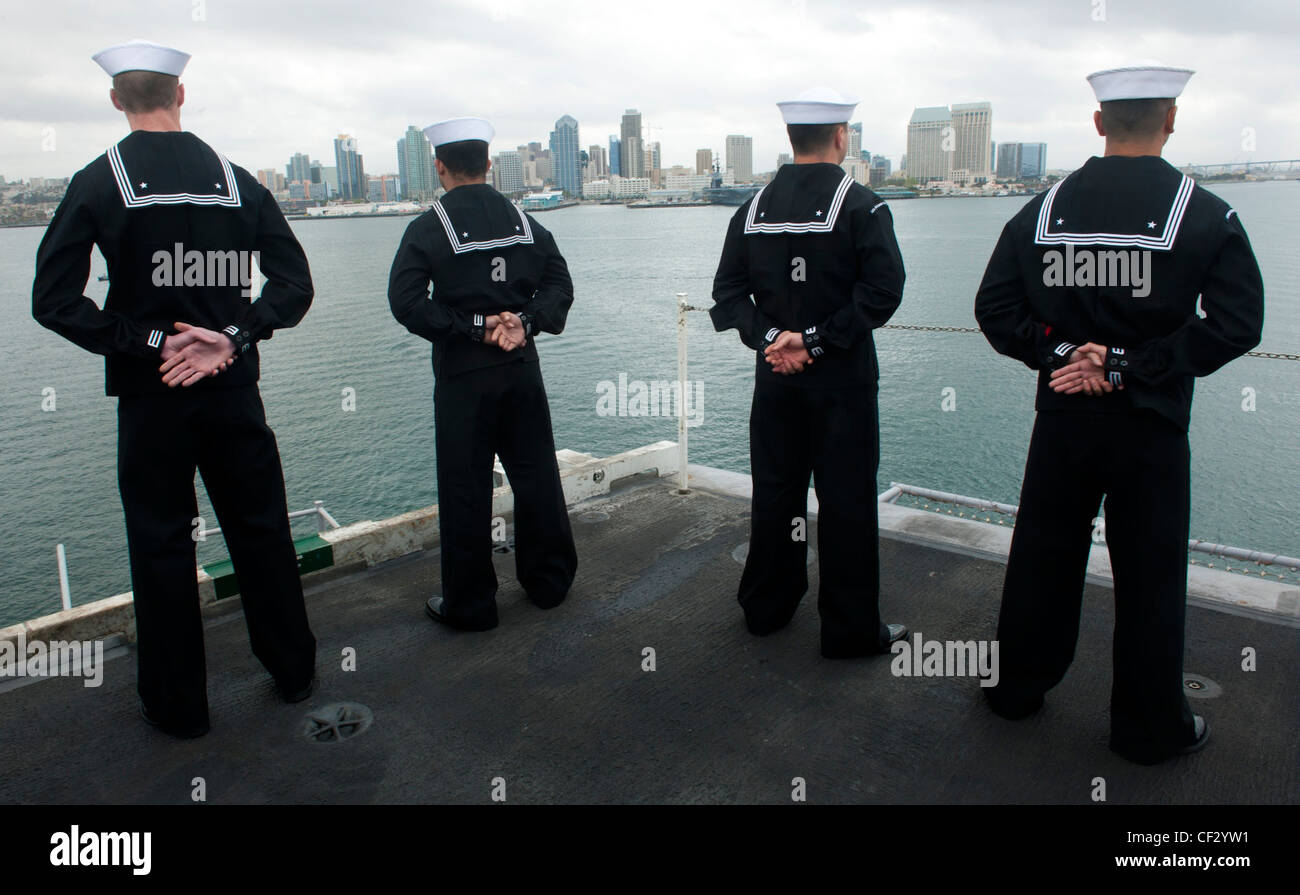 I marinai sono l'uomo delle rotaie sul ponte di volo della compagnia aerea di classe Nimitz USS John C. Stennis (CVN 74), mentre la nave entra a San Diego. John C. Stennis torna a homeport a Bremerton, Washington, dopo aver completato un dispiegamento di sette mesi. Foto Stock