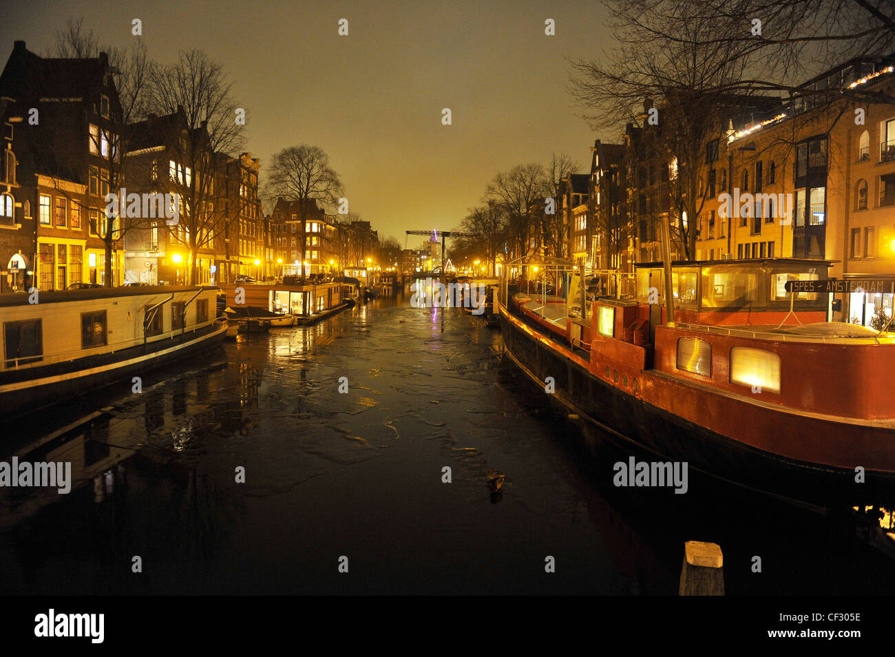 Case galleggianti di notte su un canale congelati in Amsterdam, Paesi Bassi durante il freddo inverno di febbraio 2012. Foto Stock