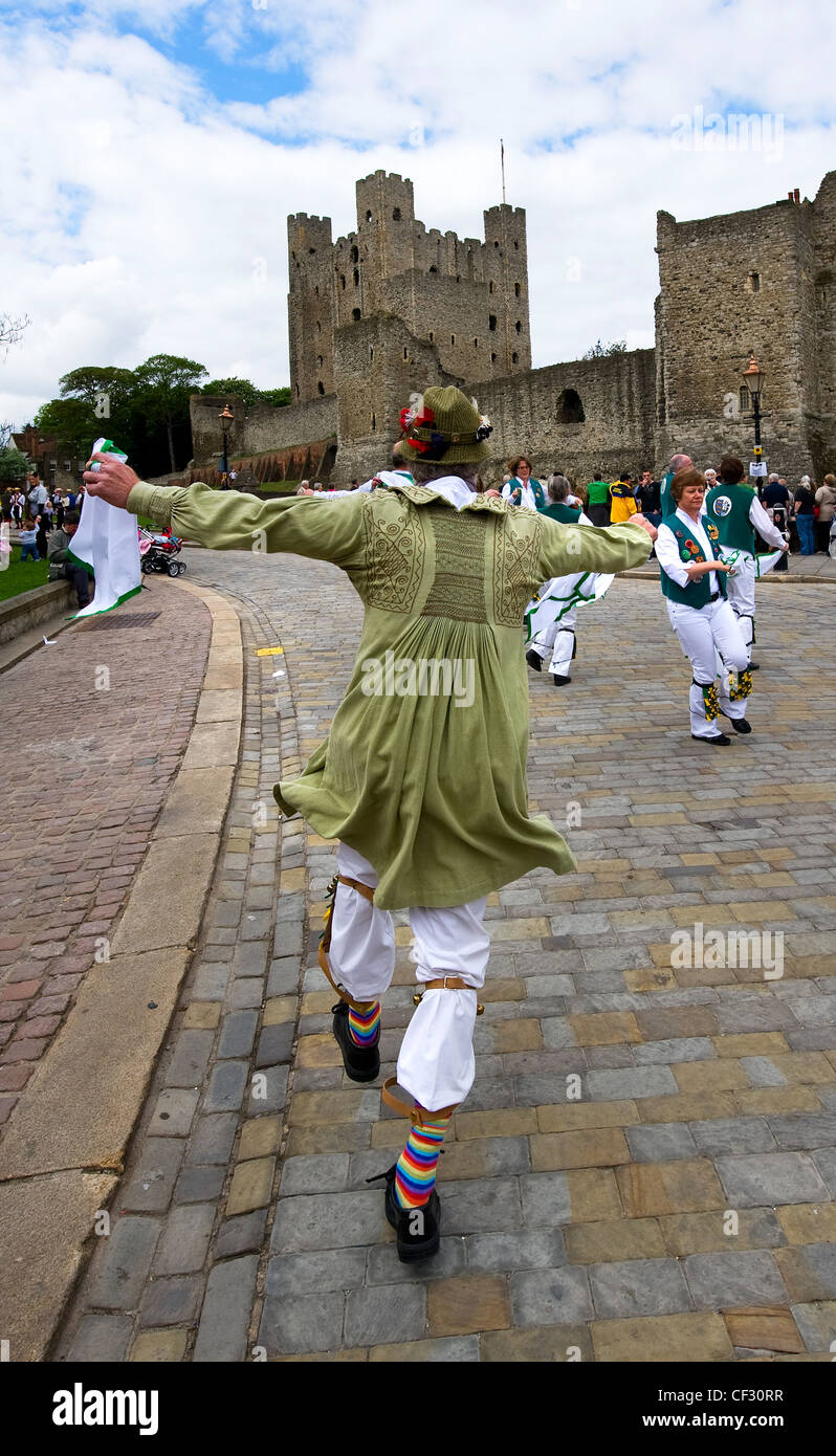 Una Morris dancing fool e femmina morris ballerini di eseguire al di fuori di Rochester Castle in occasione dell'annuale Festival spazia in Medway. Foto Stock