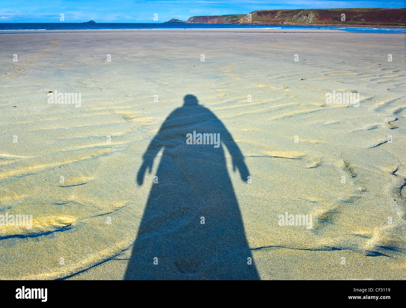 Una minacciosa ombra di una persona sulla spiaggia con la bassa marea a Sennen Cove. Foto Stock