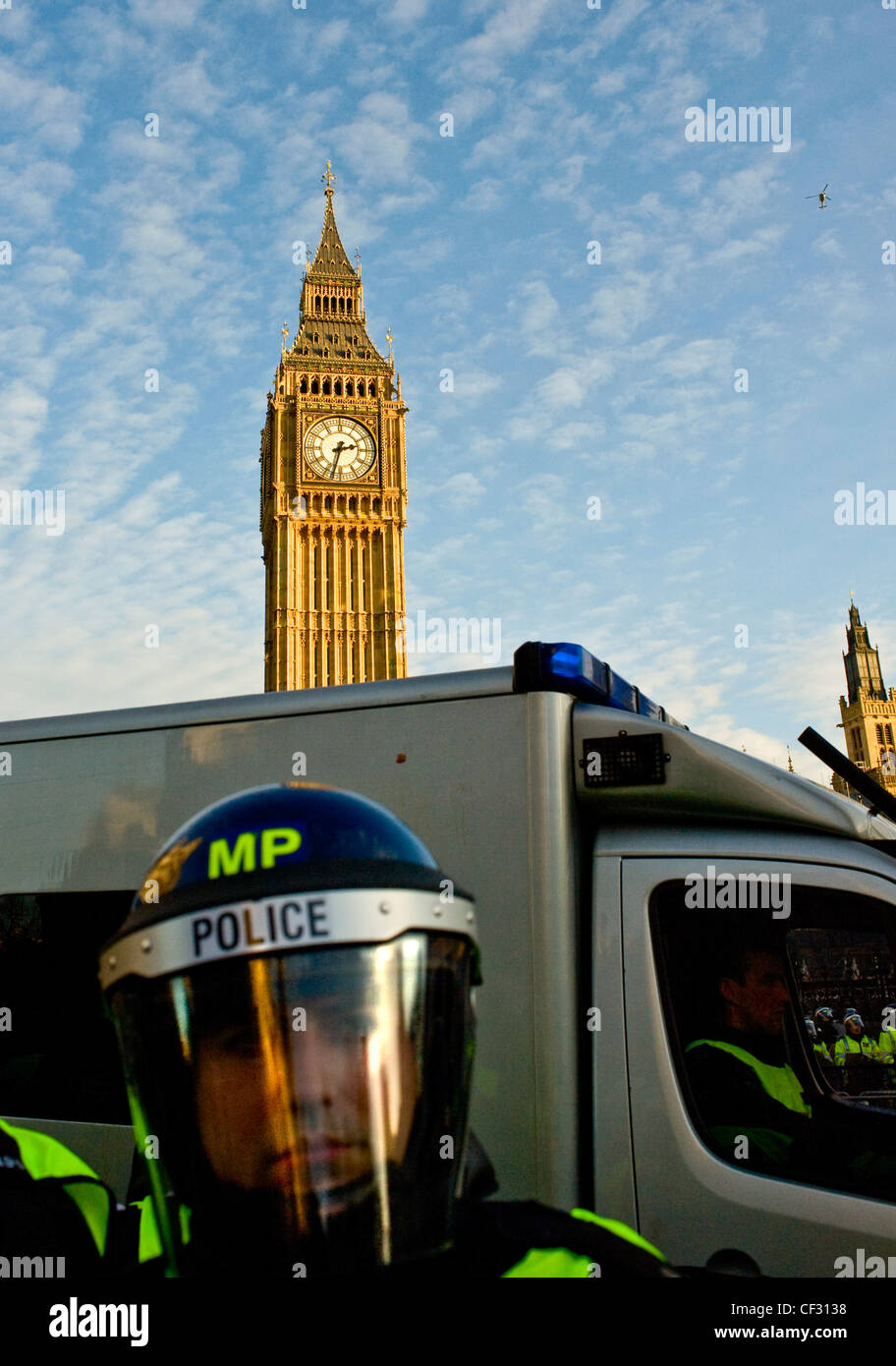 Metropolitan riot police officer preparando per una manifestazione studentesca al di fuori della sede del Parlamento. Foto Stock