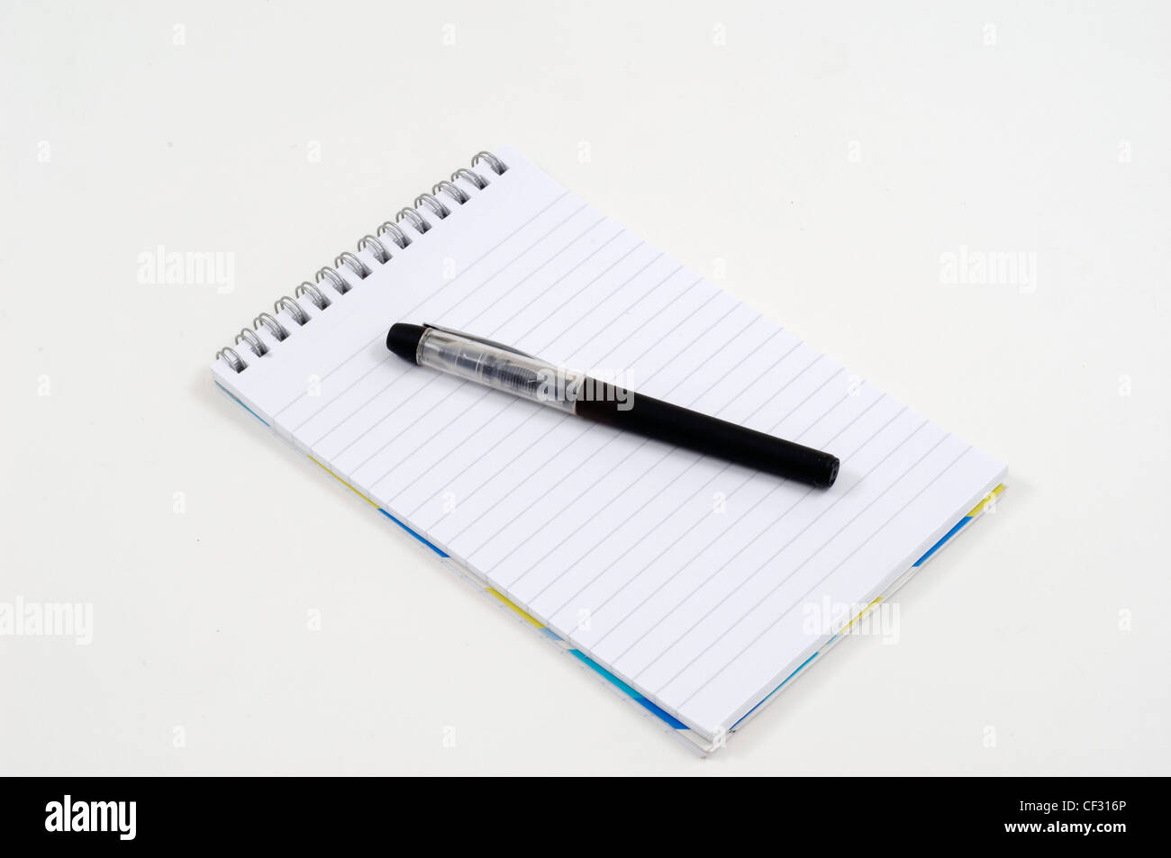 Un rilegato a spirale pad di carta con una penna nera collocata su di esso Foto Stock