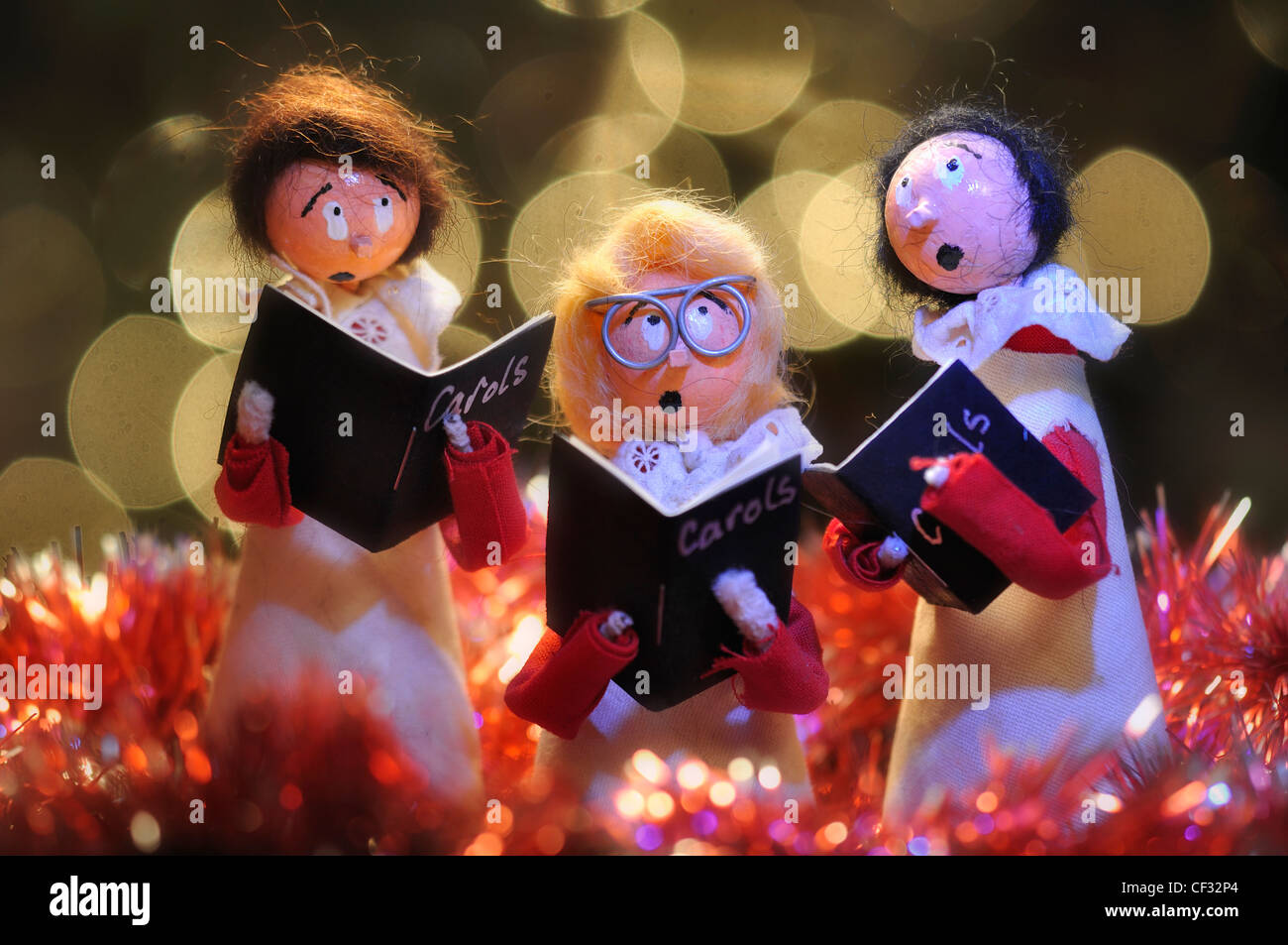 Una decorazione di Natale - tre modelli in coro boys singing tra il tinsel REGNO UNITO Foto Stock