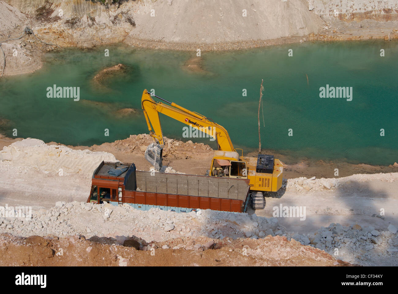 Svantaggio Mining da grande fabbrica di argilla di scavare dai bulldozer e carrello.stagno di acqua formata come l'effetto di estrazione mineraria anche sul telaio. Foto Stock
