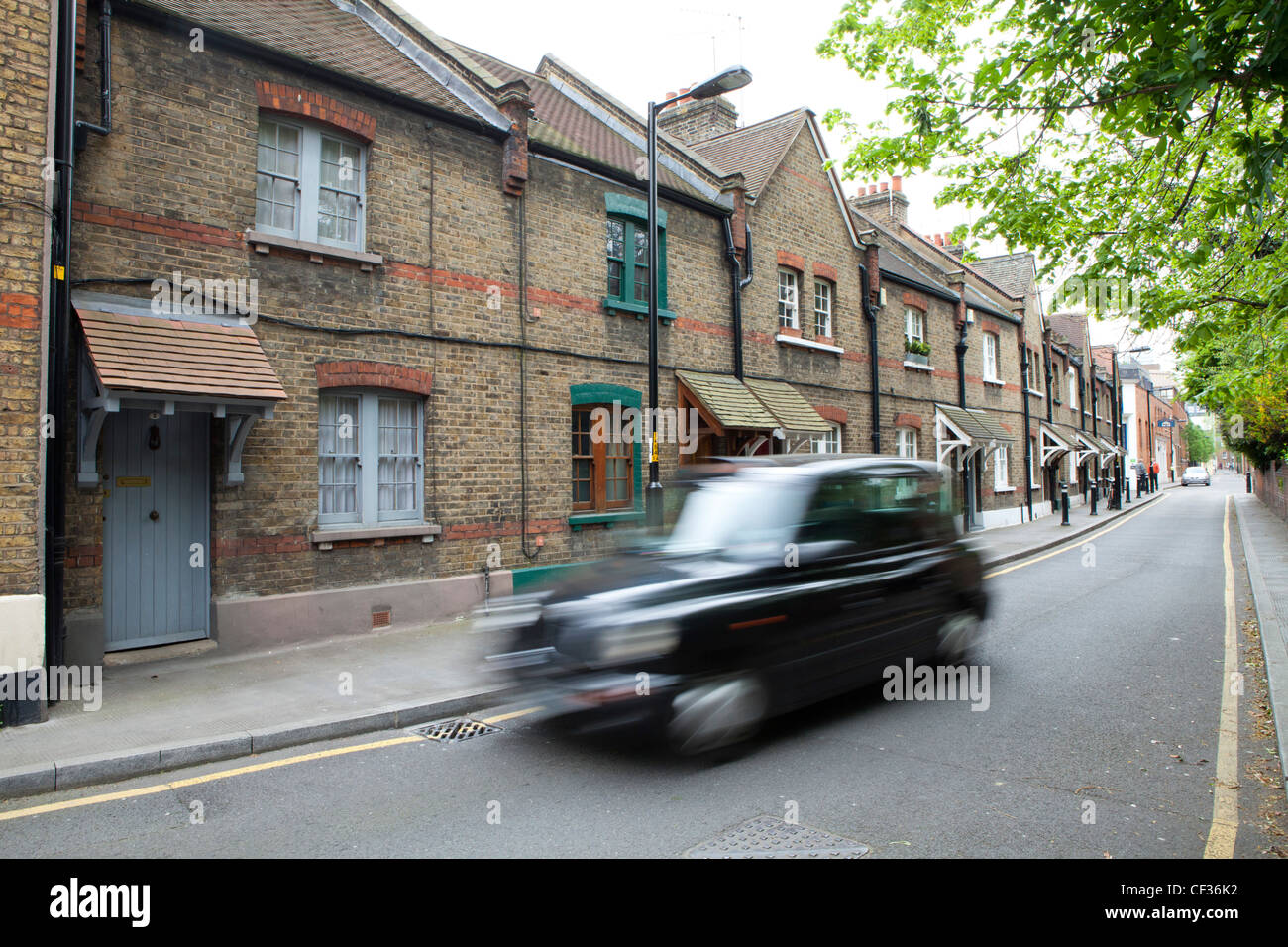 Una vista di un taxi nero in movimento lungo Copperfield Street nel quartiere londinese di Southwark Foto Stock