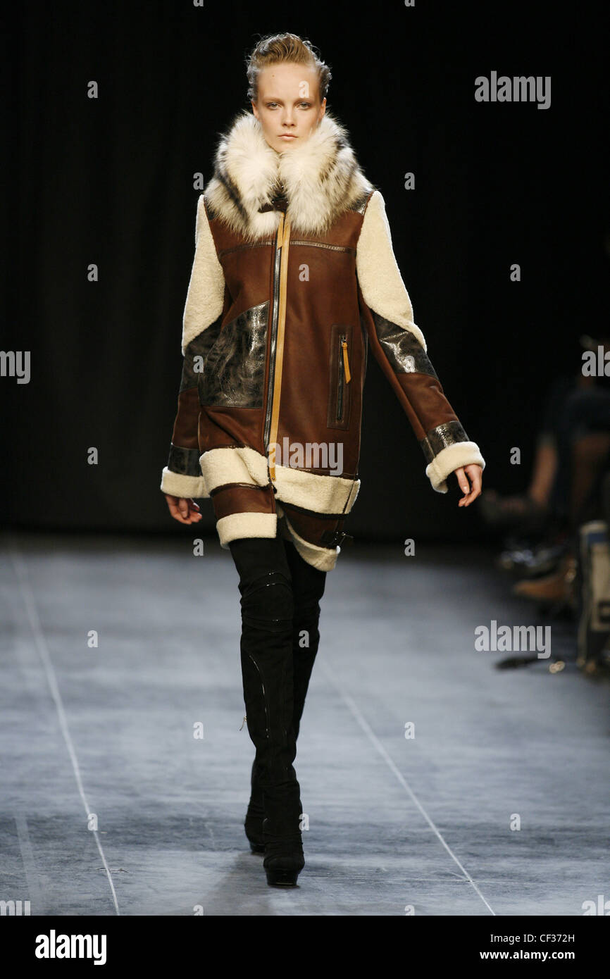 Barbara Bui Parigi pronto a indossare in autunno e inverno cappotto marrone  con collare di pelliccia e nero stivali coscia Foto stock - Alamy