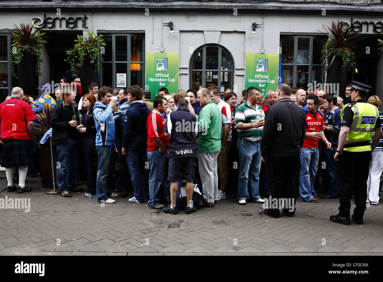 Un agente di sicurezza e le spole di mantenere un occhio vigile sul rugby fan al di fuori di un bar. Foto Stock